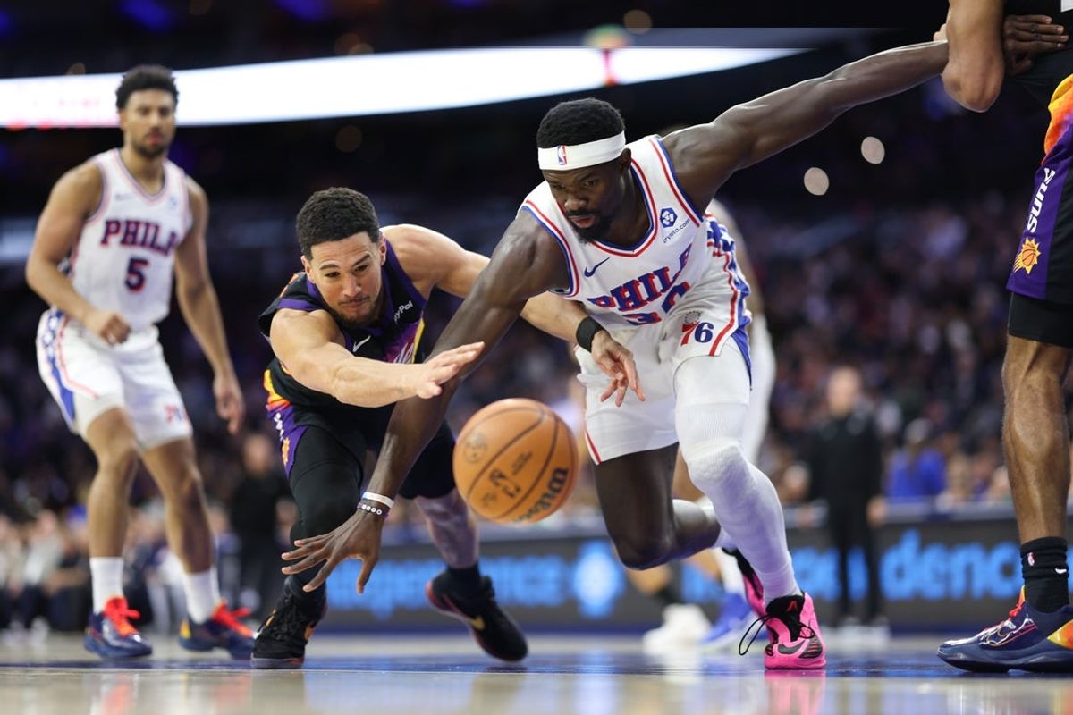 Jan 20, 2026; Philadelphia, Pennsylvania, USA; Phoenix Suns guard Devin Booker (1) and Philadelphia 76ers center Adem Bona (30) battle for a loose ball during the first quarter at Xfinity Mobile Arena. Mandatory Credit: Bill Streicher-Imagn Images