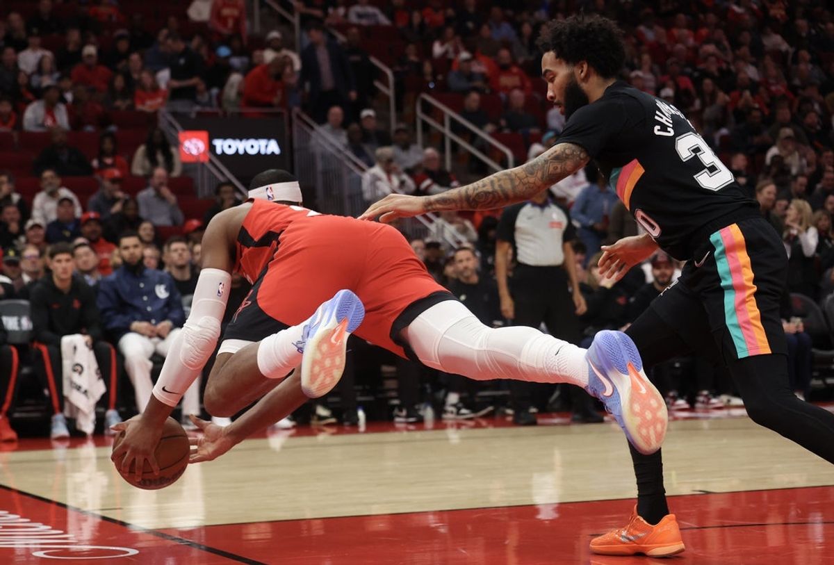 Jan 20, 2026; Houston, Texas, USA;Houston Rockets guard Josh Okogie (20) dives to save a ball against San Antonio Spurs forward Julian Champagnie (30)  in the first quarter at Toyota Center. Mandatory Credit: Thomas Shea-Imagn Images