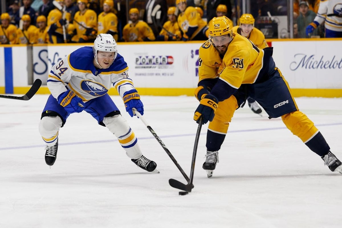 Jan 20, 2026; Nashville, Tennessee, USA;  Buffalo Sabres center Konsta Helenius (94) pokes the puck from Nashville Predators defenseman Roman Josi (59) during the second period at Bridgestone Arena. Mandatory Credit: Steve Roberts-Imagn Images