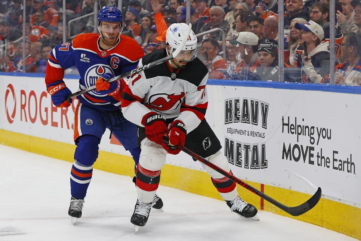 Jan 20, 2026; Edmonton, Alberta, CAN; Edmonton Oilers forward Connor McDavid (97) and New Jersey Devils defensemen Jonas Siegenthaler (71) chases a loose puck during the first period at Rogers Place. Mandatory Credit: Perry Nelson-Imagn Images