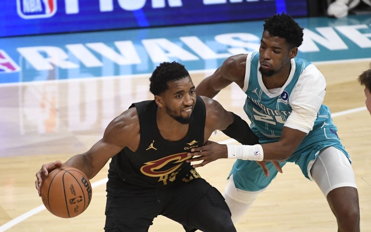 Jan 21, 2026; Charlotte, North Carolina, USA;  Cleveland Cavaliers guard Donovan Mitchell (45) drives past Charlotte Hornets guard Brandon Miller (24) during the second half at the Spectrum Center. Mandatory Credit: Sam Sharpe-Imagn Images