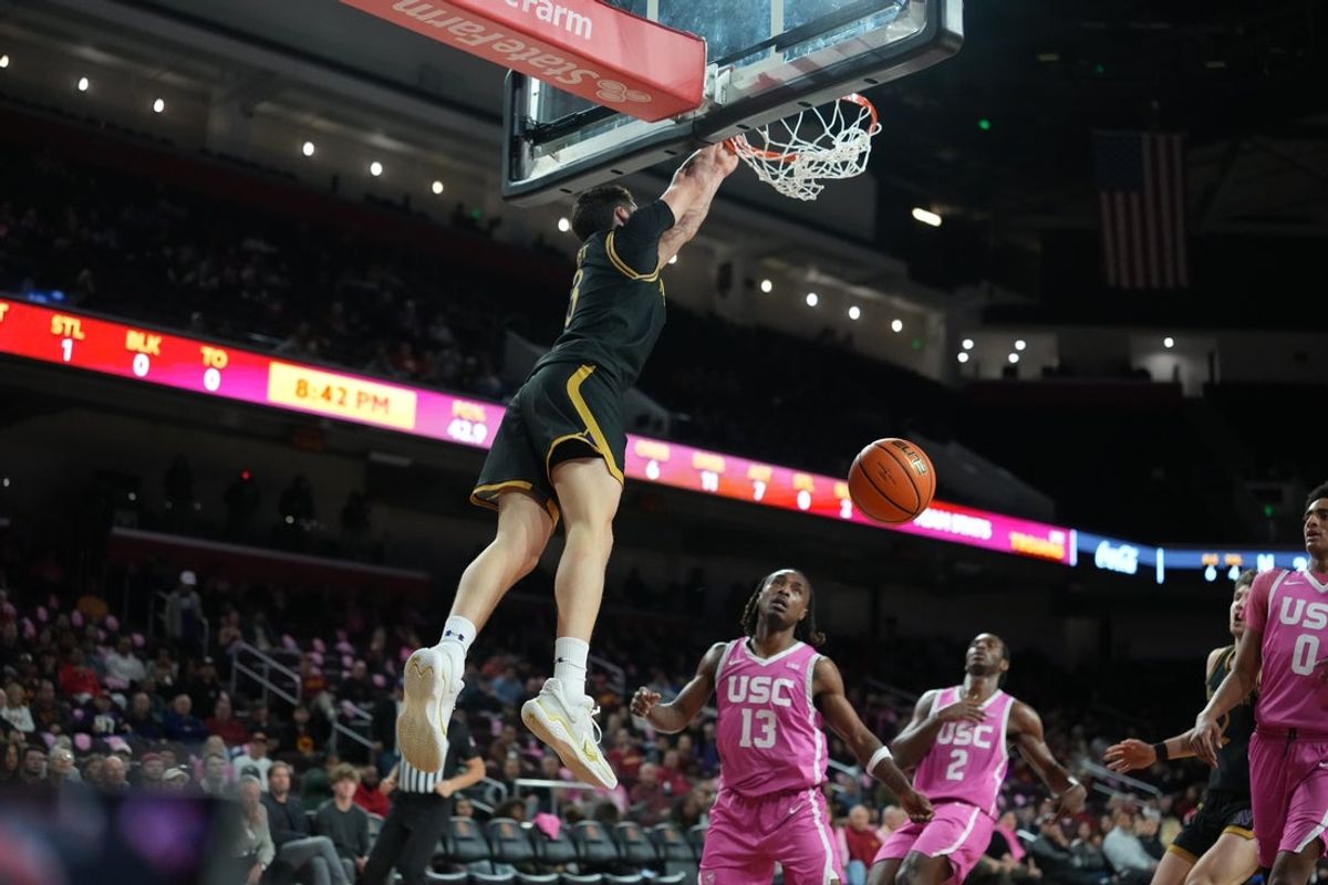 Jan 21, 2026; Los Angeles, California, USA; Northwestern Wildcats guard Jake West (3) dunks the ball against Southern California Trojans guard Kam Woods (13) n the first half at Galen Center. Mandatory Credit: Kirby Lee-Imagn Images