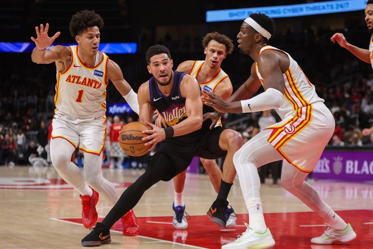 Jan 23, 2026; Atlanta, Georgia, USA; Phoenix Suns guard Devin Booker (1) is defended by Atlanta Hawks forward Jalen Johnson (1) and guard Dyson Daniels (5) and forward Onyeka Okongwu (17) in the second quarter at State Farm Arena. Mandatory Credit: Brett Davis-Imagn Images