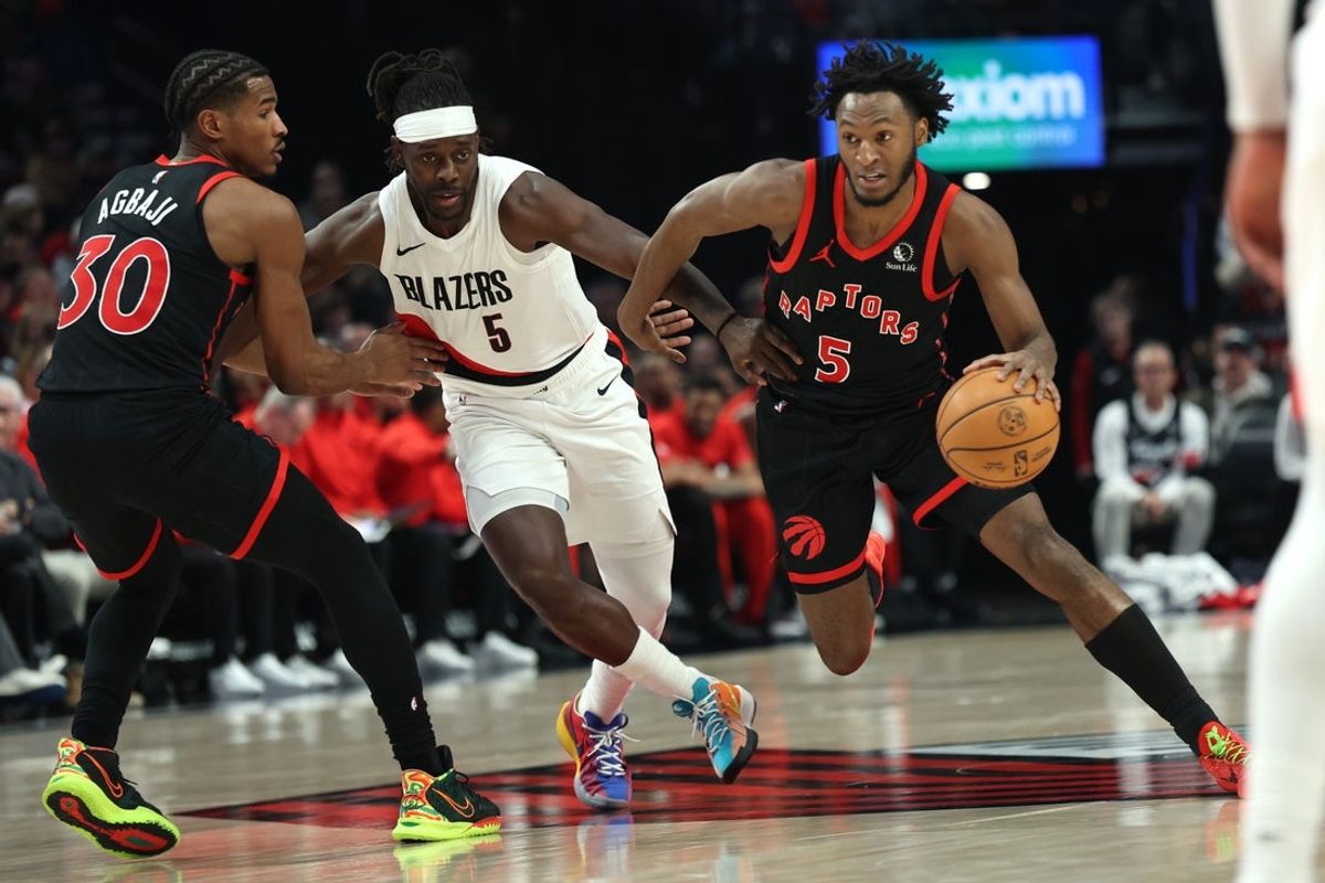 Jan 23, 2026; Portland, Oregon, USA;  Toronto Raptors guard Immanuel Quickley (5) dribbles the ball past Portland Trail Blazers guard Jrue Holiday (5) during the first half at Moda Center. Mandatory Credit: Jaime Valdez-Imagn Images