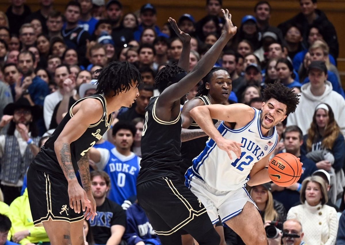 Jan 24, 2026; Durham, North Carolina, USA; Duke Blue Devils forward Cameron Boozer (12) controls the ball in front of Wake Forest Demon Deacons guard Mekhi Mason (8) during the first half at Cameron Indoor Stadium. Mandatory Credit: Rob Kinnan-Imagn Images