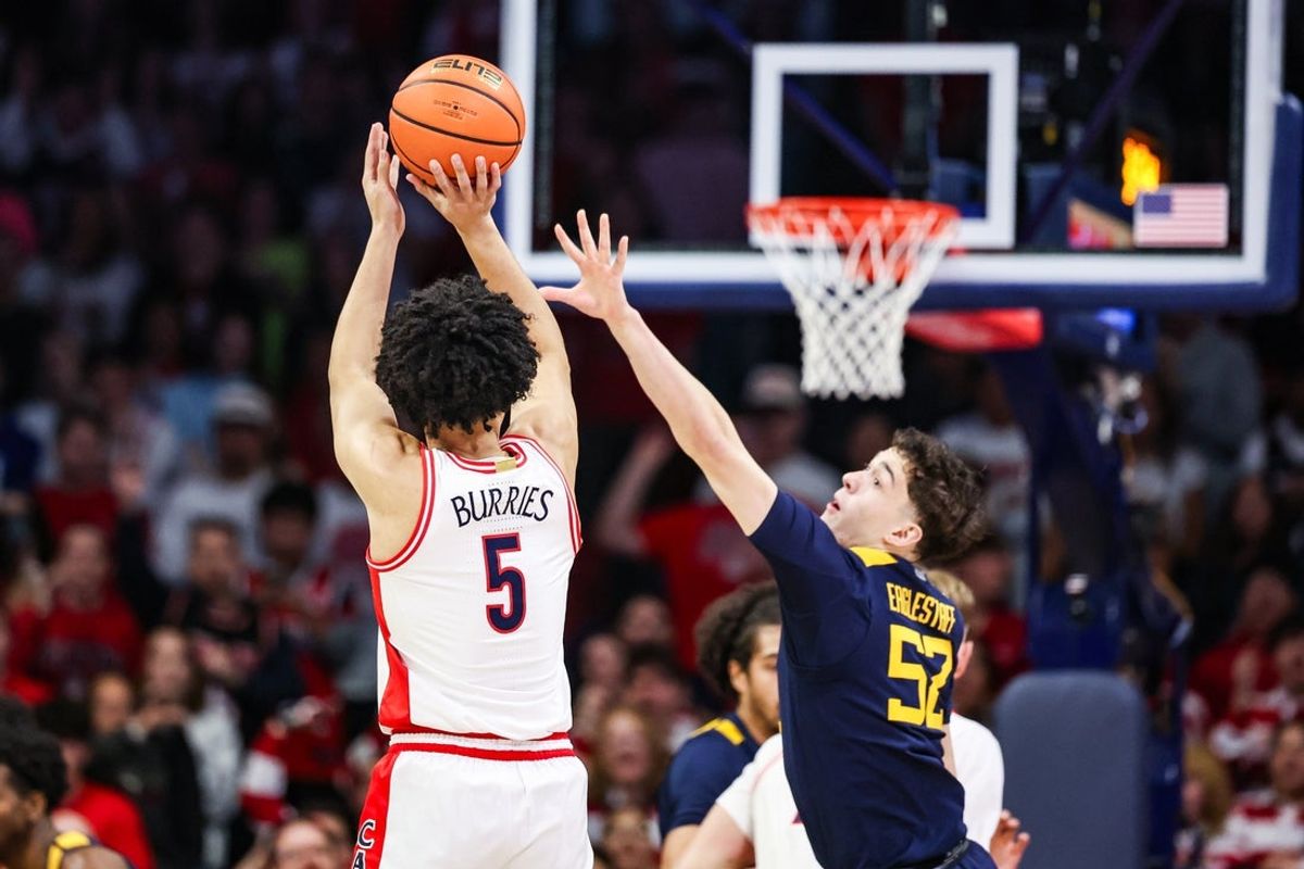 Jan 24, 2026; Tucson, Arizona, USA; Arizona Wildcats guard Brayden Burries (5) makes a three-point basket over West Virginia Mountaineers guard Treysen Eaglestaff (52) during the first half of the game at McKale Memorial Center. Mandatory Credit: Aryanna Frank-Imagn Images