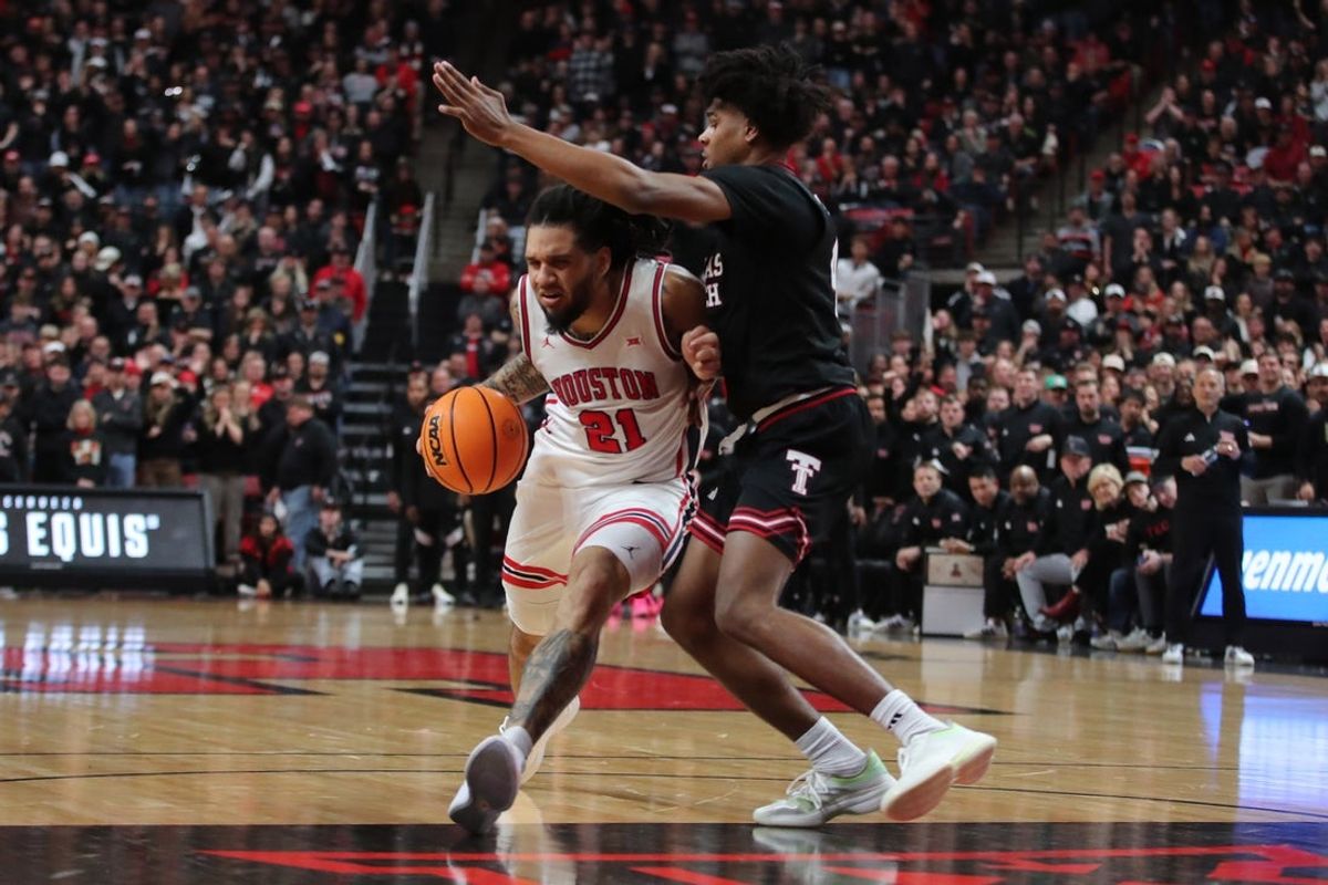 Jan 24, 2026; Lubbock, Texas, USA;  Houston Cougars guard Emanuel Sharp (21) drives the ball against Texas Tech Red Raiders guard Christian Anderson (4) in the second half at United Supermarkets Arena. Mandatory Credit: Michael C. Johnson-Imagn Images