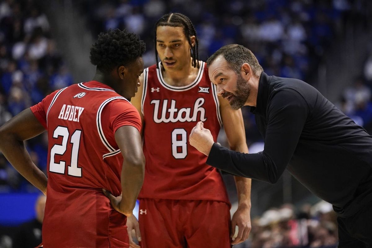 Jan 24, 2026; Provo, Utah, USA; Utah Utes head coach Alex Jensen speaks to Utah Utes guard Obomate Abbey (21) forward Keanu Dawes (8) during the first half against the BYU Cougars at Marriott Center. Mandatory Credit: Aaron Baker-Imagn Images