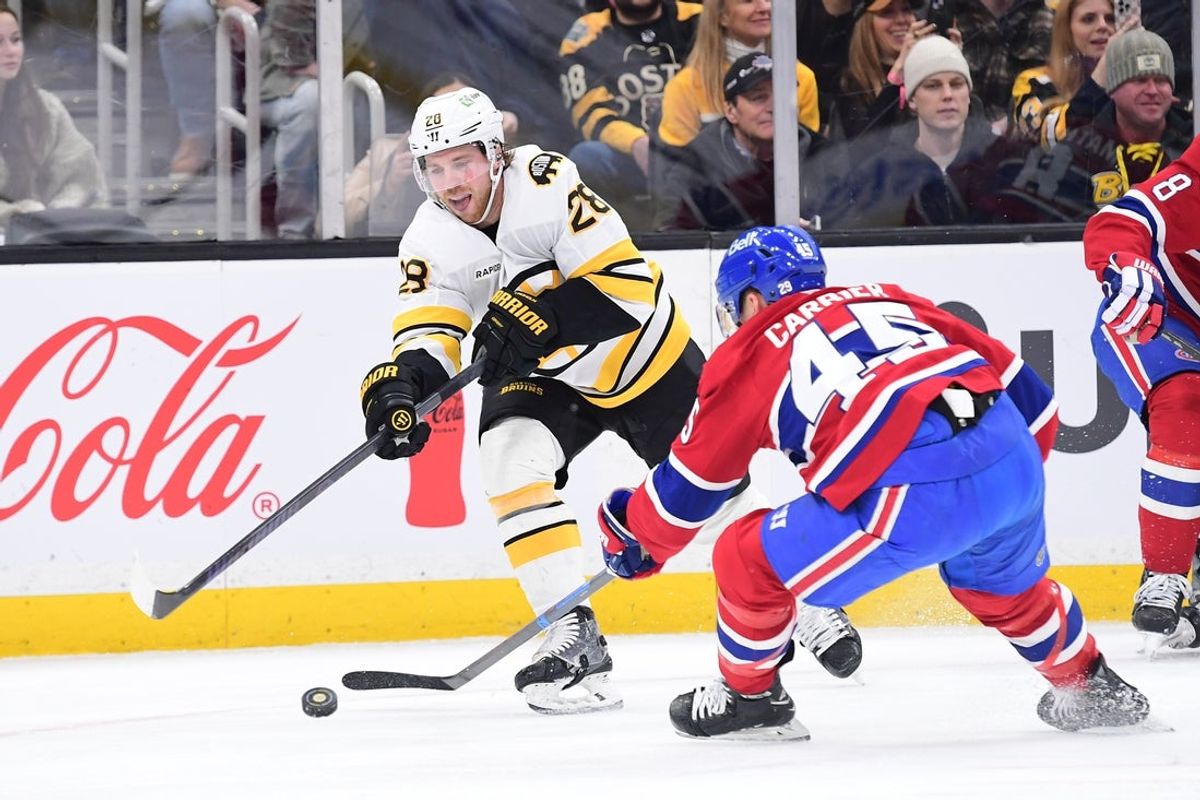 Jan 24, 2026; Boston, Massachusetts, USA; Boston Bruins center Elias Lindholm (28) passes the puck past Montreal Canadiens defenseman Alexandre Carrier (45) during the first period at TD Garden. Mandatory Credit: Bob DeChiara-Imagn Images