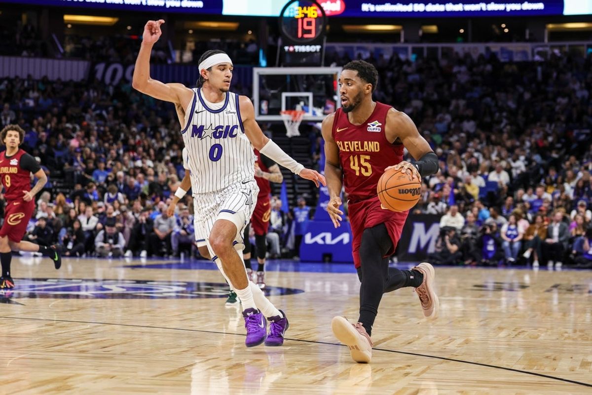Jan 24, 2026; Orlando, Florida, USA; Cleveland Cavaliers guard Donovan Mitchell (45) brings the ball up court against Orlando Magic guard Anthony Black (0) during the second half at Kia Center. Mandatory Credit: Mike Watters-Imagn Images
