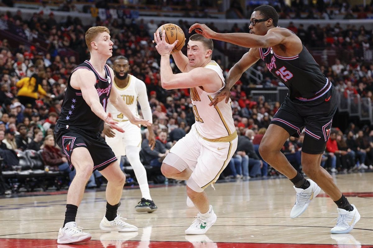Jan 24, 2026; Chicago, Illinois, USA; Boston Celtics guard Payton Pritchard (11) drives to the basket against Chicago Bulls guard Kevin Huerter (13) and forward Jalen Smith (25) during the second half at United Center. Mandatory Credit: Kamil Krzaczynski-Imagn Images