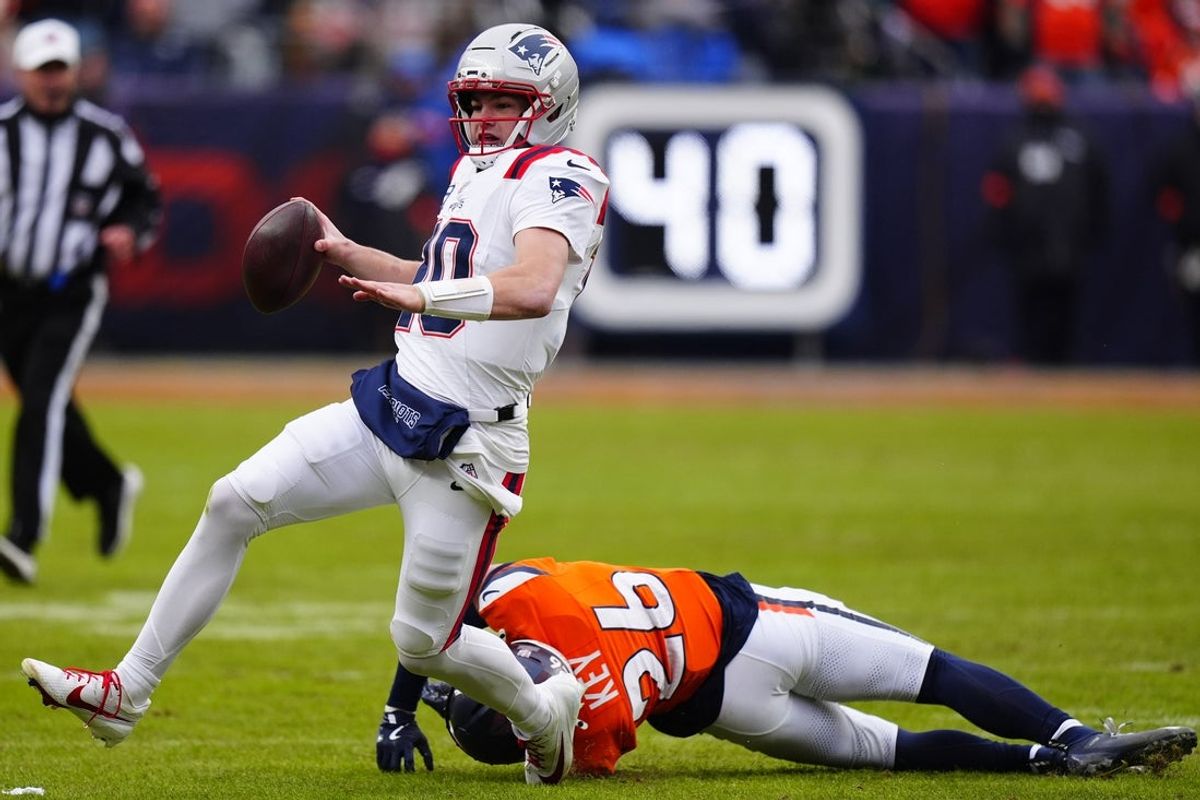 Jan 25, 2026; Denver, CO, USA; New England Patriots quarterback Drake Maye (10) rushes the ball against Denver Broncos safety Devon Key (26) during the first half in the 2026 AFC Championship Game at Empower Field at Mile High. Mandatory Credit: Ron Chenoy-Imagn Images
