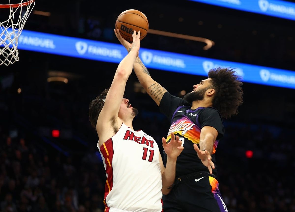 Jan 25, 2026; Phoenix, Arizona, USA; Phoenix Suns forward Isaiah Livers (18) drives to the basket against Miami Heat forward Jaime Jaquez Jr. (11) in the first half at Mortgage Matchup Center. Mandatory Credit: Mark J. Rebilas-Imagn Images