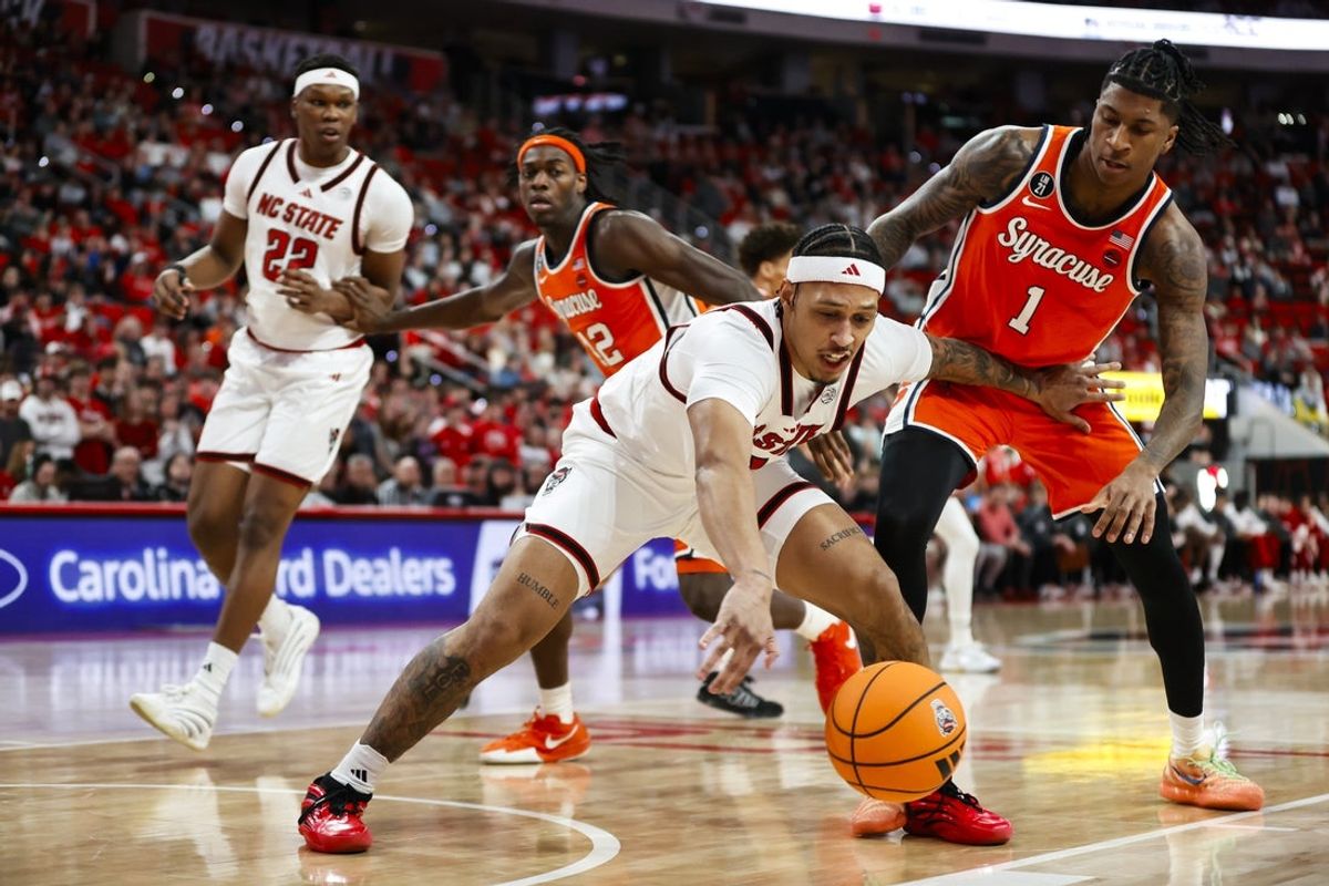 Jan 27, 2026; Raleigh, North Carolina, USA; NC State Wolfpack forward Darrion Williams (1) reaches for the ball guarded by Syracuse Orange forward Donnie Freeman (1) during the first half of the game at Lenovo Center. Mandatory Credit: Jaylynn Nash-Imagn Images