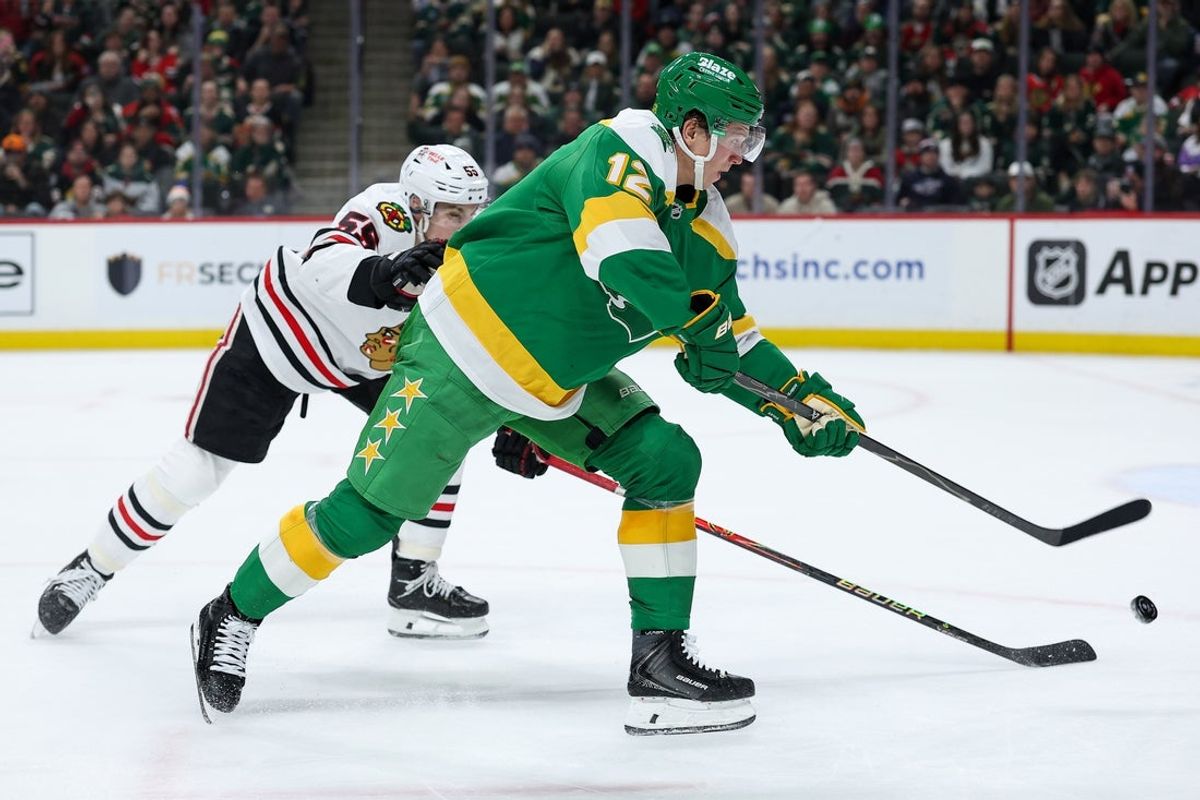 Jan 27, 2026; Saint Paul, Minnesota, USA; Minnesota Wild left wing Matt Boldy (12) shoots as Chicago Blackhawks defenseman Artyom Levshunov (55) defends during the second period at Grand Casino Arena. Mandatory Credit: Matt Krohn-Imagn Images