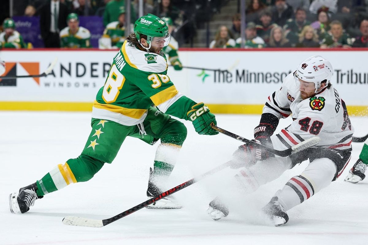 Jan 27, 2026; Saint Paul, Minnesota, USA; Minnesota Wild right wing Ryan Hartman (38) shoots as Chicago Blackhawks defenseman Matt Grzelcyk (48) defends during the second period at Grand Casino Arena. Mandatory Credit: Matt Krohn-Imagn Images