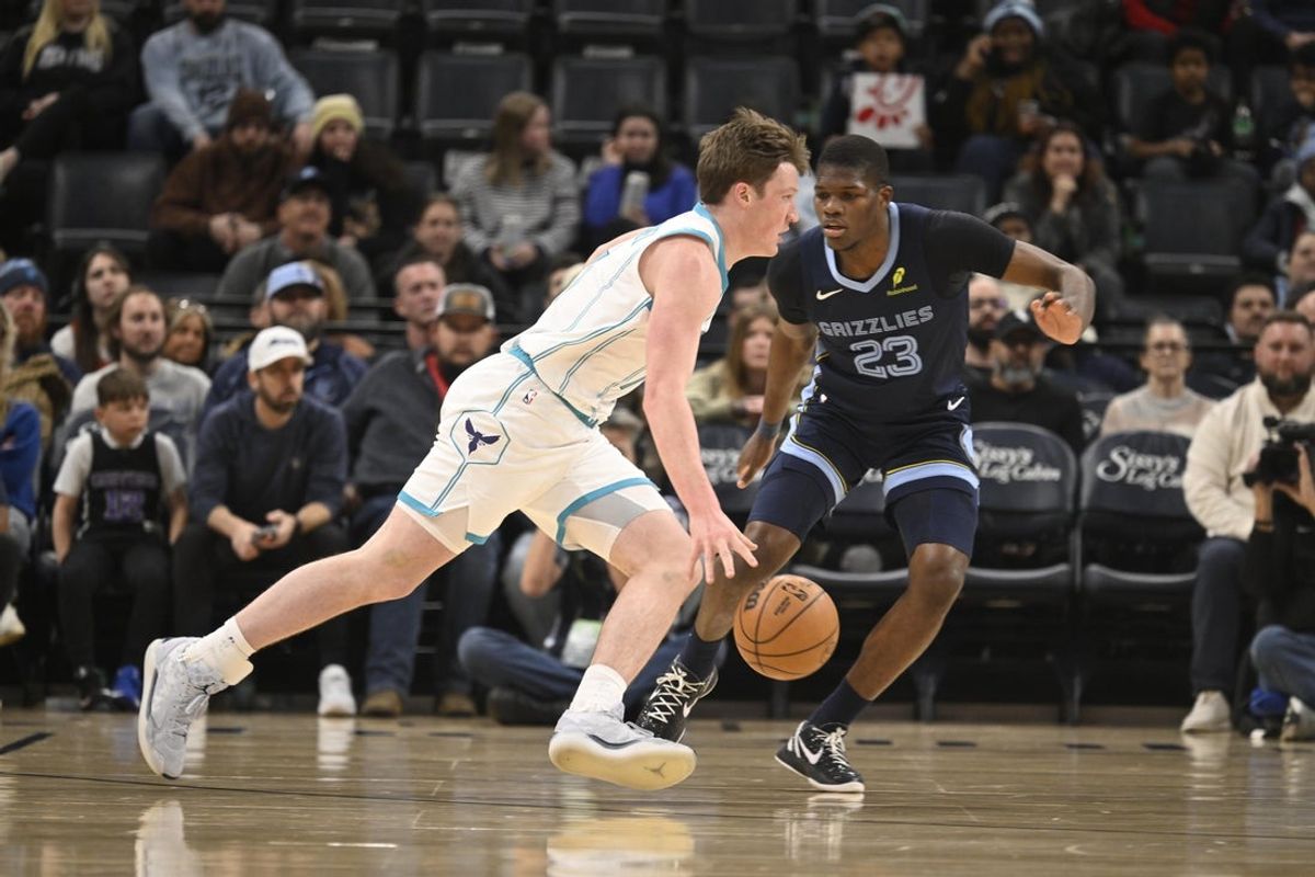 Jan 28, 2026; Memphis, Tennessee, USA; Charlotte Hornets guard Kon Knueppel (7) drives past defender Memphis Grizzlies forward Jalen Wells (0) in the first quarter at FedExForum. Mandatory Credit: Matthew Smith-Imagn Images