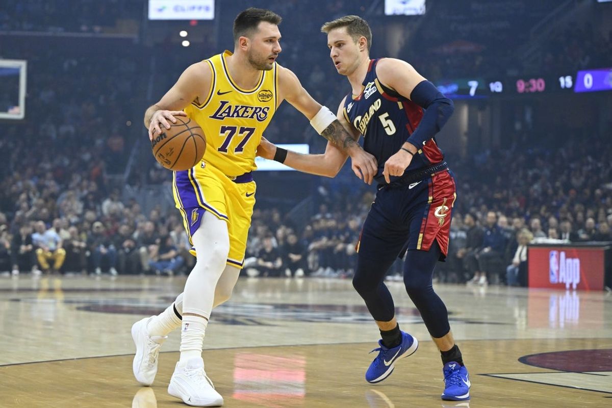 Jan 28, 2026; Cleveland, Ohio, USA; Los Angeles Lakers guard Luka Doncic (77) dribbles beside Cleveland Cavaliers guard Sam Merrill (5) in the first quarter at Rocket Arena. Mandatory Credit: David Richard-Imagn Images
