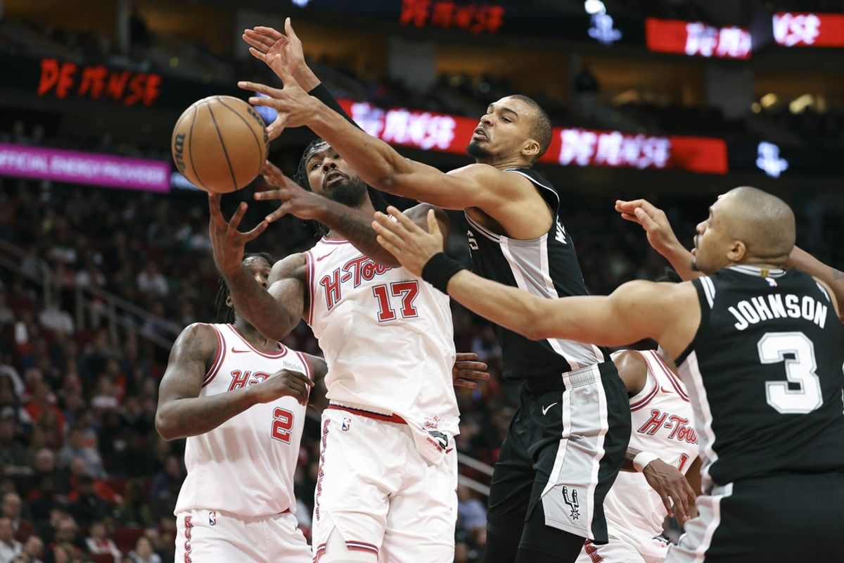 Jan 28, 2026; Houston, Texas, USA; Houston Rockets forward Tari Eason (17) and San Antonio Spurs forward Victor Wembanyama (1) battle for a loose ball during the fourth quarter at Toyota Center. Mandatory Credit: Troy Taormina-Imagn Images