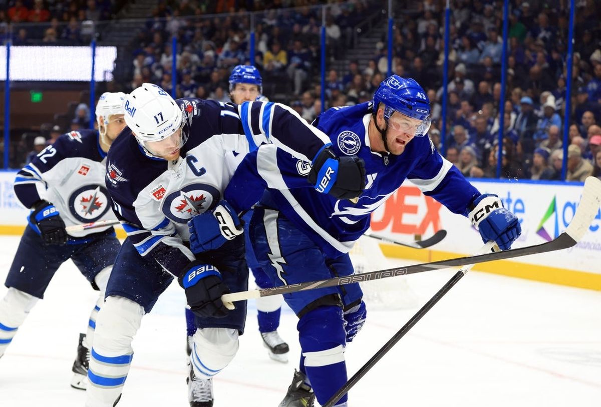 Jan 29, 2026; Tampa, Florida, USA; Winnipeg Jets center Adam Lowry (17) and Tampa Bay Lightning defenseman Darren Raddysh (43) skate towards the puck during the second period at Benchmark International Arena. Mandatory Credit: Kim Klement Neitzel-Imagn Images