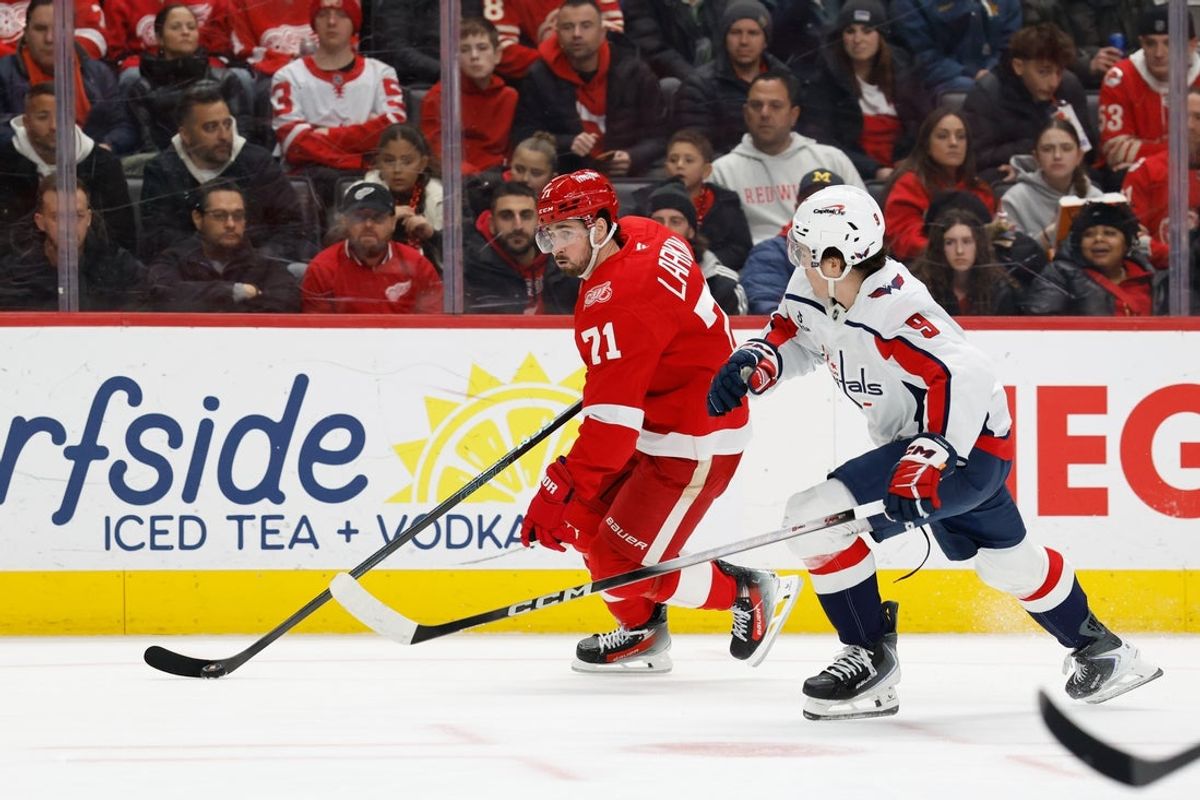 Jan 29, 2026; Detroit, Michigan, USA;  Detroit Red Wings center Dylan Larkin (71) skates with the puck defended by Washington Capitals right wing Ryan Leonard (9) in the second period at Little Caesars Arena. Mandatory Credit: Rick Osentoski-Imagn Images