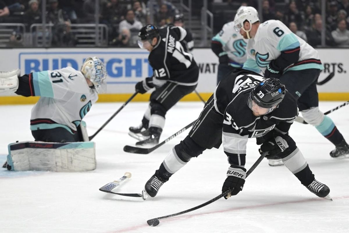 Apr 3, 2024; Los Angeles, California, USA; Los Angeles Kings left wing Viktor Arvidsson (33) passes the puck behind him to Los Angeles Kings left wing Trevor Moore (12) as he scores his second goal of the game past Seattle Kraken goaltender Philipp Grubauer (31) in the second period at Crypto.com Arena.