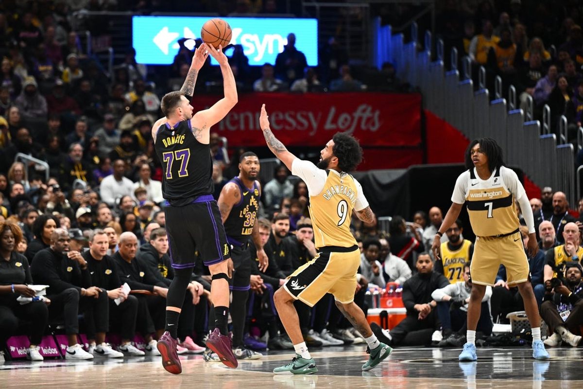 Jan 30, 2026; Washington, District of Columbia, USA; Los Angeles Lakers forward/guard Luka Doncic (77) shoots over Washington Wizards guard/forward Justin Champagnie (9) during the first half at Capital One Arena. Mandatory Credit: Brad Mills-Imagn Images