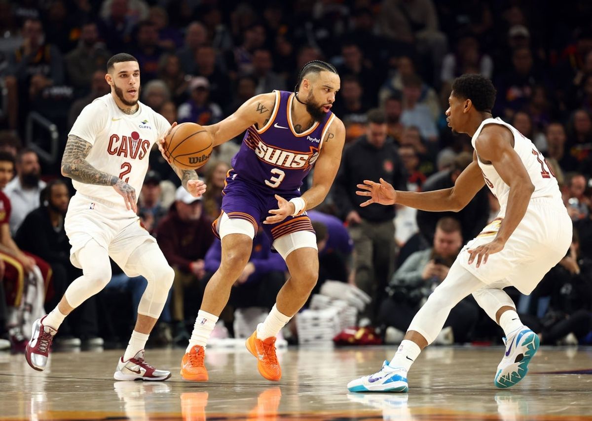Jan 30, 2026; Phoenix, Arizona, USA; Phoenix Suns forward Dillon Brooks (3) moves the ball against Cleveland Cavaliers guard Lonzo Ball (2) and forward De'Andre Hunter (12) in the first half at Mortgage Matchup Center. Mandatory Credit: Mark J. Rebilas-Imagn Images