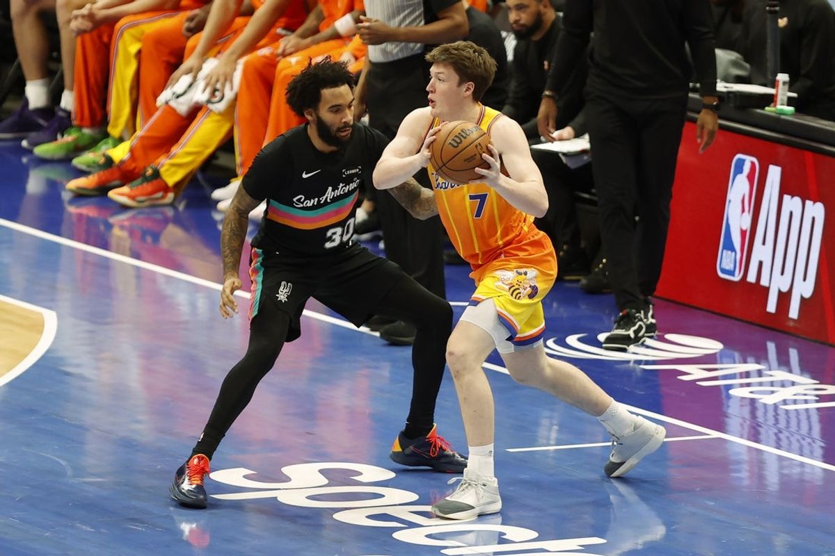 Jan 31, 2026; Charlotte, North Carolina, USA; Charlotte Hornets guard Kon Knueppel (7) is guarded by San Antonio Spurs forward Julian Champagnie (30) during the first quarter at Spectrum Center. Mandatory Credit: Brian Westerholt-Imagn Images