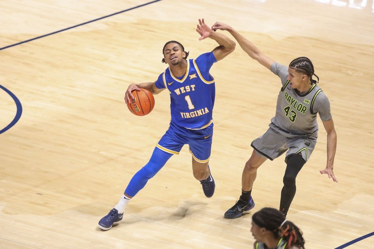 Jan 31, 2026; Morgantown, West Virginia, USA; West Virginia Mountaineers guard Jasper Floyd (1) dribbles against Baylor Bears guard Cameron Carr (43) during the second half at Hope Coliseum. Mandatory Credit: Ben Queen-Imagn Images