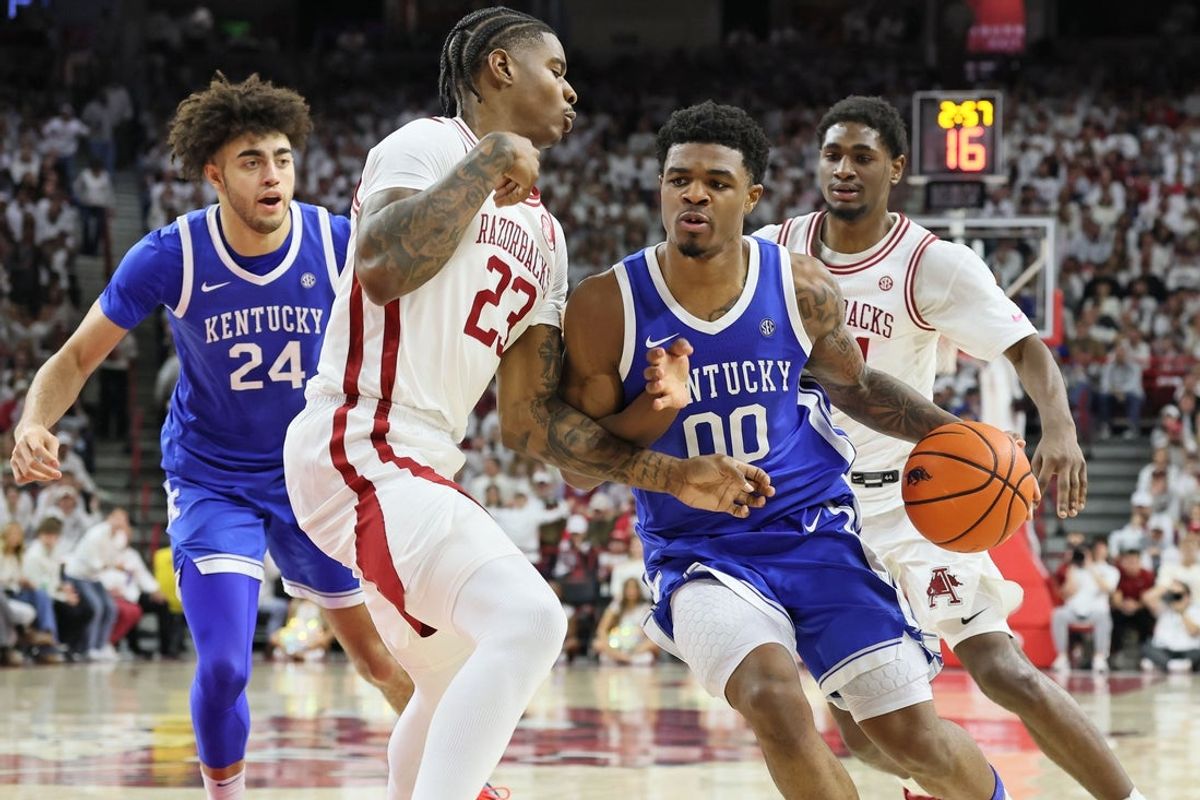 Jan 31, 2026; Fayetteville, Arkansas, USA; Kentucky Wildcats guard Otega Oweh (00) drives against Arkansas Razorbacks forward Nick Pringle (23) during the first half at Bud Walton Arena. Mandatory Credit: Nelson Chenault-Imagn Images