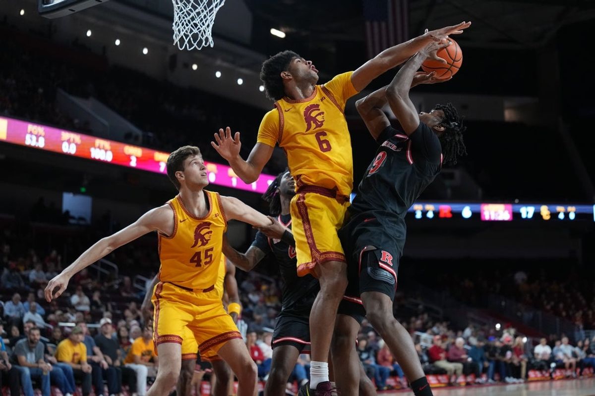 Jan 31, 2026; Los Angeles, California, USA; Rutgers Scarlet Knights forward Dylan Grant (9) shoots the ball against Southern California Trojans forward Jacob Cofie (6) and center Gabe Dynes (45) in the first half at Galen Center. Mandatory Credit: Kirby Lee-Imagn Images