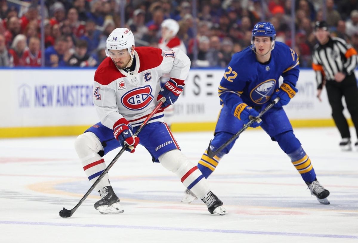 Jan 31, 2026; Buffalo, New York, USA;  Buffalo Sabres right wing Jack Quinn (22) watches as Montréal Canadiens center Nick Suzuki (14) skates with the puck during the first period at KeyBank Center. Mandatory Credit: Timothy T. Ludwig-Imagn Images