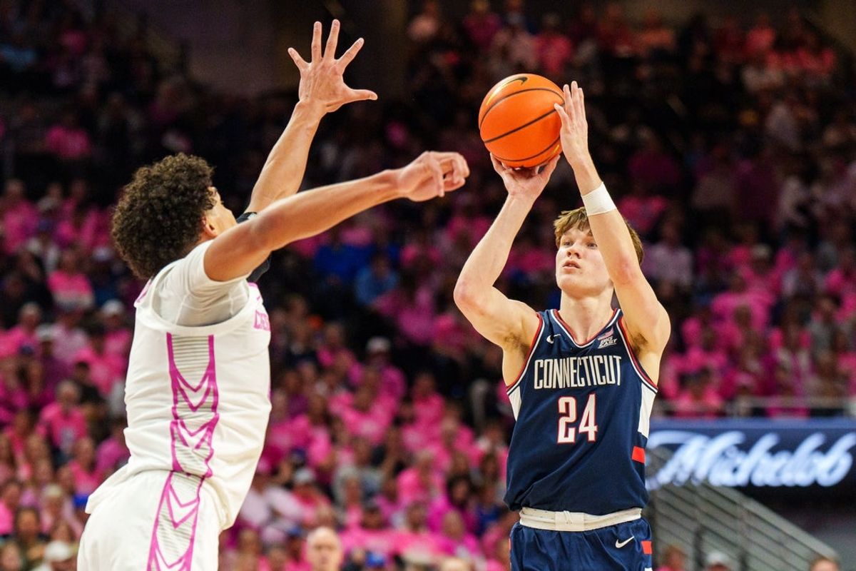 Jan 31, 2026; Omaha, Nebraska, USA; Connecticut Huskies guard Braylon Mullins (24) shoots a three point shot against Creighton Bluejays forward Jasen Green (0) during the first half at CHI Health Center Omaha. Mandatory Credit: Dylan Widger-Imagn Images