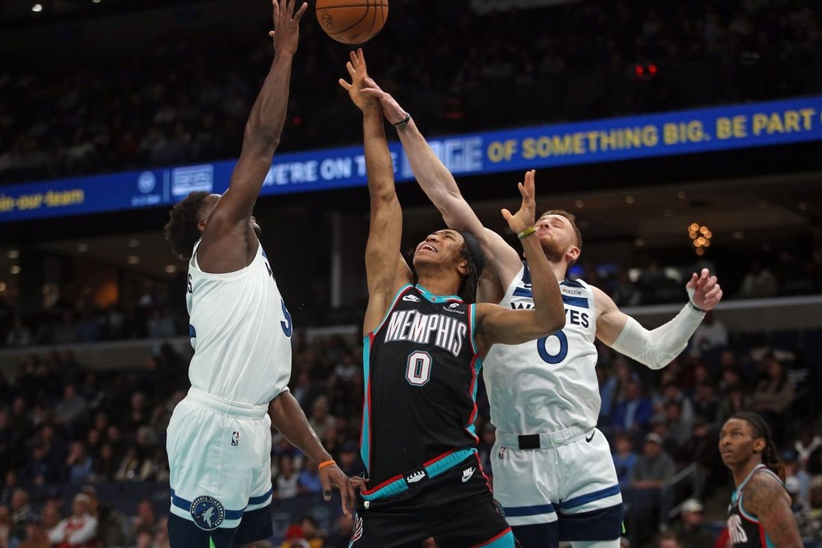 Jan 31, 2026; Memphis, Tennessee, USA; Memphis Grizzlies forward Jaylen Wells (0) shoots as Minnesota Timberwolves guard Anthony Edwards (5) and guard Donte DiVincenzo (0) defend during the first quarter at FedExForum. Mandatory Credit: Petre Thomas-Imagn Images