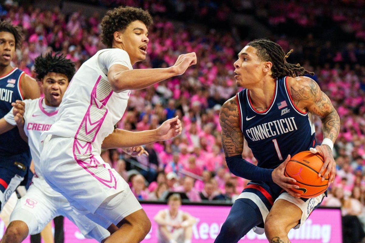 Jan 31, 2026; Omaha, Nebraska, USA; Connecticut Huskies guard Solo Ball (1) looks to shoot against Creighton Bluejays forward Jasen Green (0) during the first half at CHI Health Center Omaha. Mandatory Credit: Dylan Widger-Imagn Images