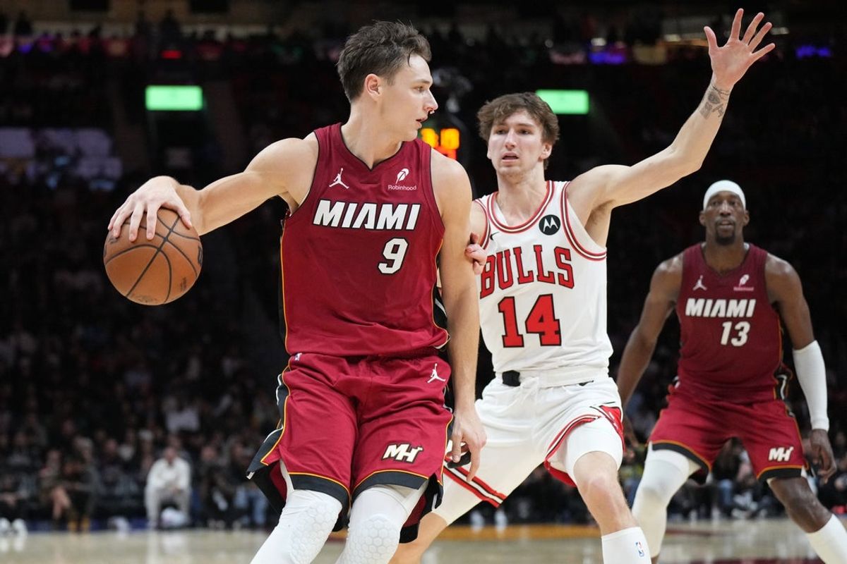Jan 31, 2026; Miami, Florida, USA;  Miami Heat guard Pelle Larsson (9) drives to the baseline as Chicago Bulls forward Matas Buzelis (14) defends during the second half at Kaseya Center. Mandatory Credit: Jim Rassol-Imagn Images