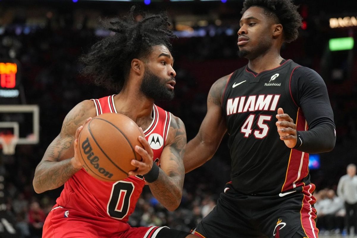 Feb 1, 2026; Miami, Florida, USA;  Chicago Bulls guard Coby White (0) looks to pass as Miami Heat guard Davion Mitchell (45) defends during the first half at Kaseya Center. Mandatory Credit: Jim Rassol-Imagn Images