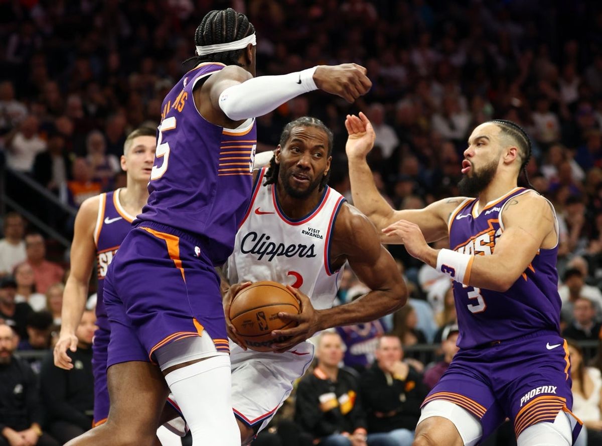 Feb 1, 2026; Phoenix, Arizona, USA; Los Angeles Clippers forward Kawhi Leonard (2) drives to the basket against Phoenix Suns forward Dillon Brooks (3) and center Mark Williams (15) in the first half at Mortgage Matchup Center. Mandatory Credit: Mark J. Rebilas-Imagn Images
