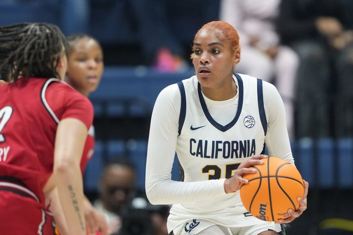 Feb 1, 2026; Berkeley, California, USA; California Golden Bears center Sakima Walker (center) handles the ball against Louisville Cardinals guard Imari Berry (left) during the second quarter at Haas Pavilion. Mandatory Credit: Darren Yamashita-Imagn Images