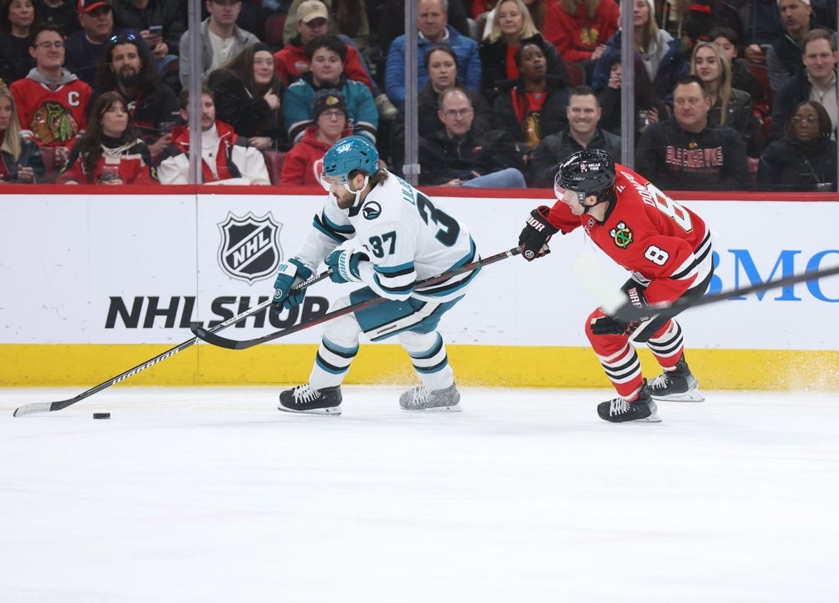 Feb 2, 2026; Chicago, Illinois, USA; San Jose Sharks defenseman Timothy Liljegren (37) and Chicago Blackhawks center Ryan Donato (8) battle for control of the puck during the first period at United Center. Mandatory Credit: Talia Sprague-Imagn Images