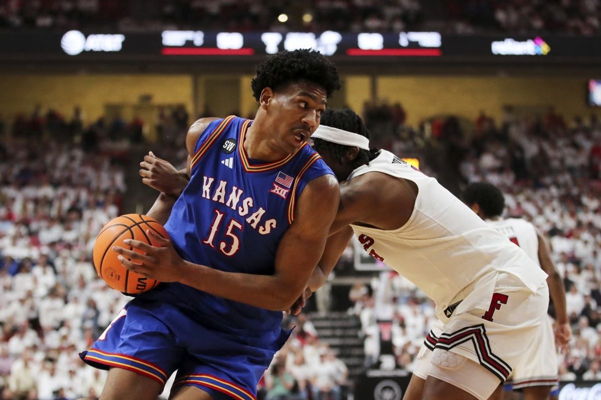 Feb 2, 2026; Lubbock, Texas, USA;  Kansas Jayhawks guard Bryson Tiller (15) drives the ball around Texas Tech Red Raiders guard Tyeree Byran (1) in the second half at United Supermarkets Arena. Mandatory Credit: Michael C. Johnson-Imagn Images