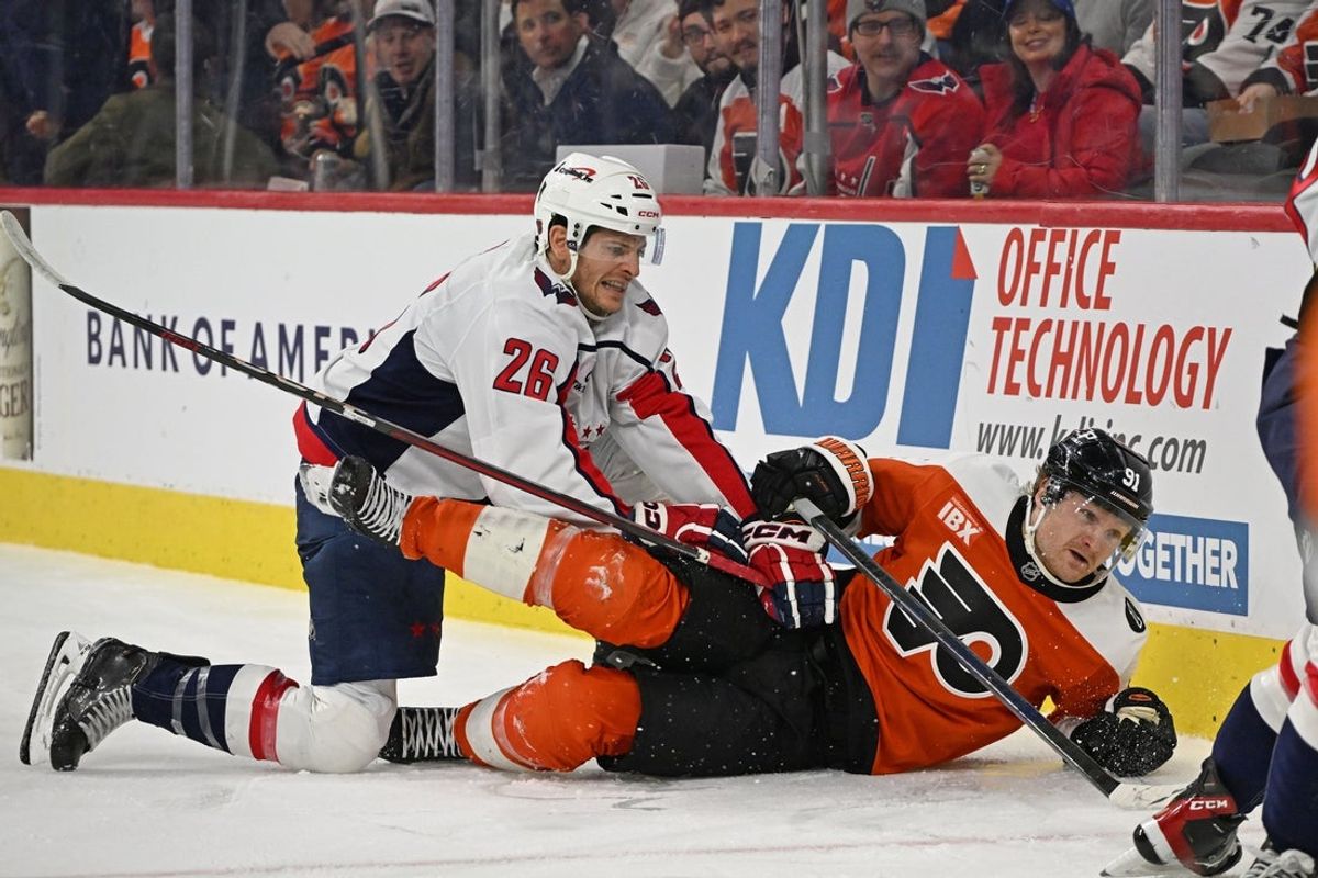 Feb 3, 2026; Philadelphia, Pennsylvania, USA; Washington Capitals center Nic Dowd (26) finishes his check against Philadelphia Flyers right wing Carl Grundstrom (91) during the first period at Xfinity Mobile Arena. Mandatory Credit: Eric Hartline-Imagn Images
