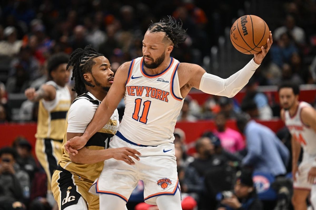 Feb 3, 2026; Washington, District of Columbia, USA; New York Knicks guard Jalen Brunson (11) keeps the ball away from Washington Wizards guard Sharife Cooper (13) during the first quarter at Capital One Arena. Mandatory Credit: Rafael Suanes-Imagn Images