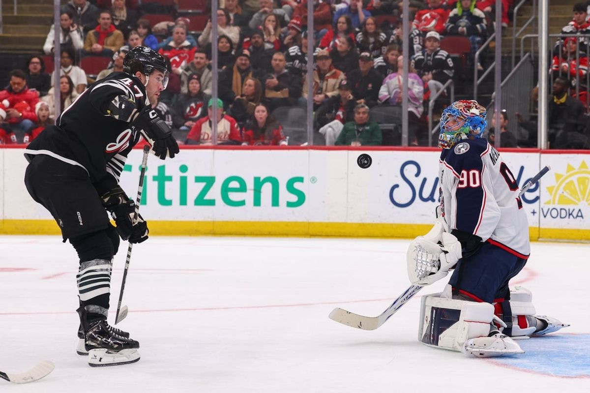 Feb 3, 2026; Newark, New Jersey, USA; Columbus Blue Jackets goaltender Elvis Merzlikins (90) makes a save as New Jersey Devils left wing Paul Cotter (47) looks for the puck during the second period at Prudential Center. Mandatory Credit: Ed Mulholland-Imagn Images