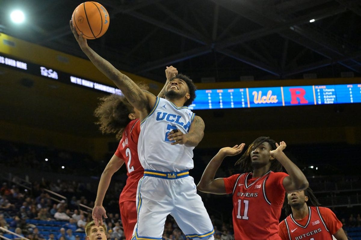 Feb 3, 2026; Los Angeles, California, USA;  UCLA Bruins guard Donovan Dent (2) is defended by Rutgers Scarlet Knights guard Lino Mark (2) as he drives past forward Chris Nwuli (11) to the basket in the first half at Pauley Pavilion presented by Wescom Financial. Mandatory Credit: Jayne Kamin-Oncea-Imagn Images