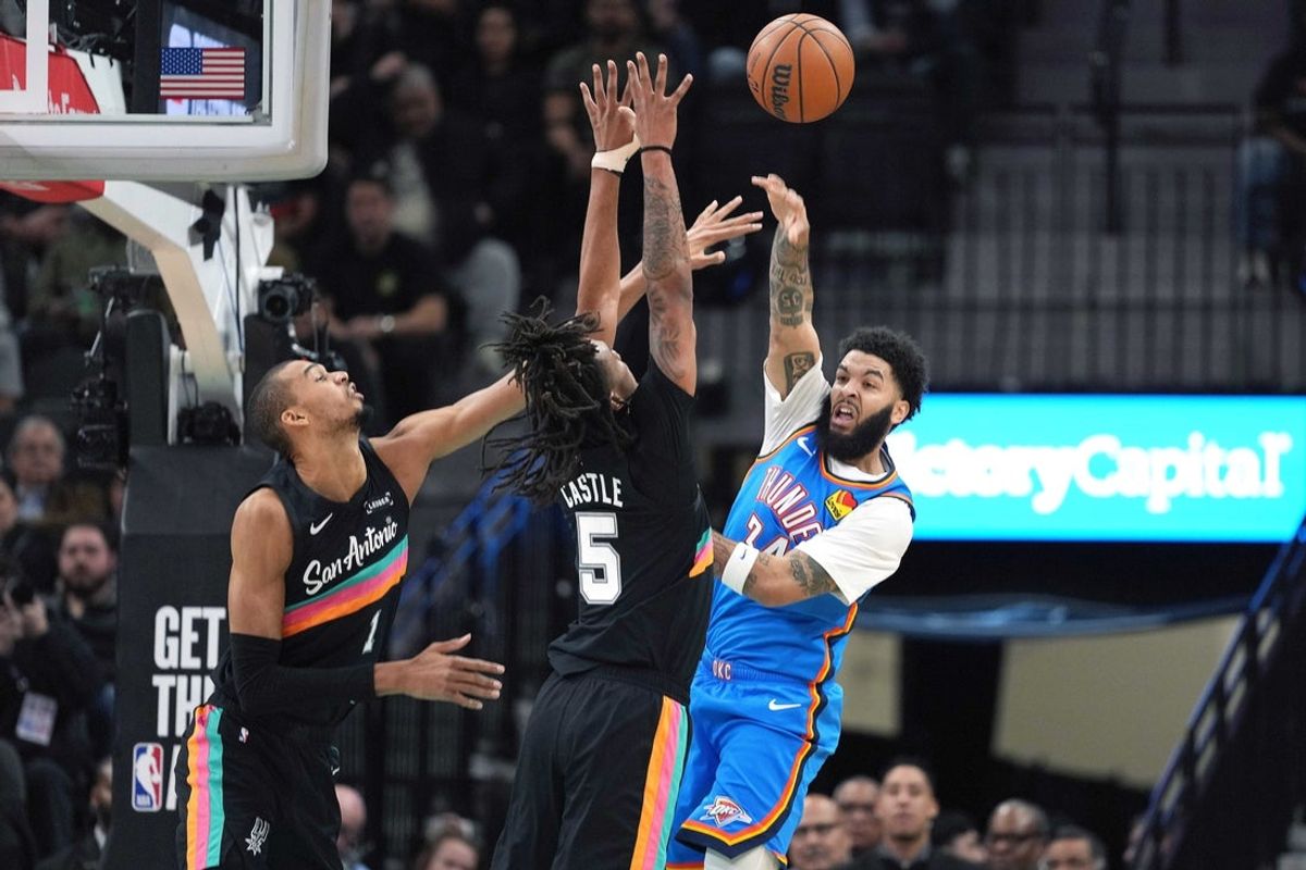 Feb 4, 2026; San Antonio, Texas, USA; Oklahoma City Thunder forward Kenrich Williams (34) passes the ball over San Antonio Spurs forward Victor Wembanyama (1) and guard Stephon Castle (5) during the first half at Frost Bank Center. Mandatory Credit: Scott Wachter-Imagn Images