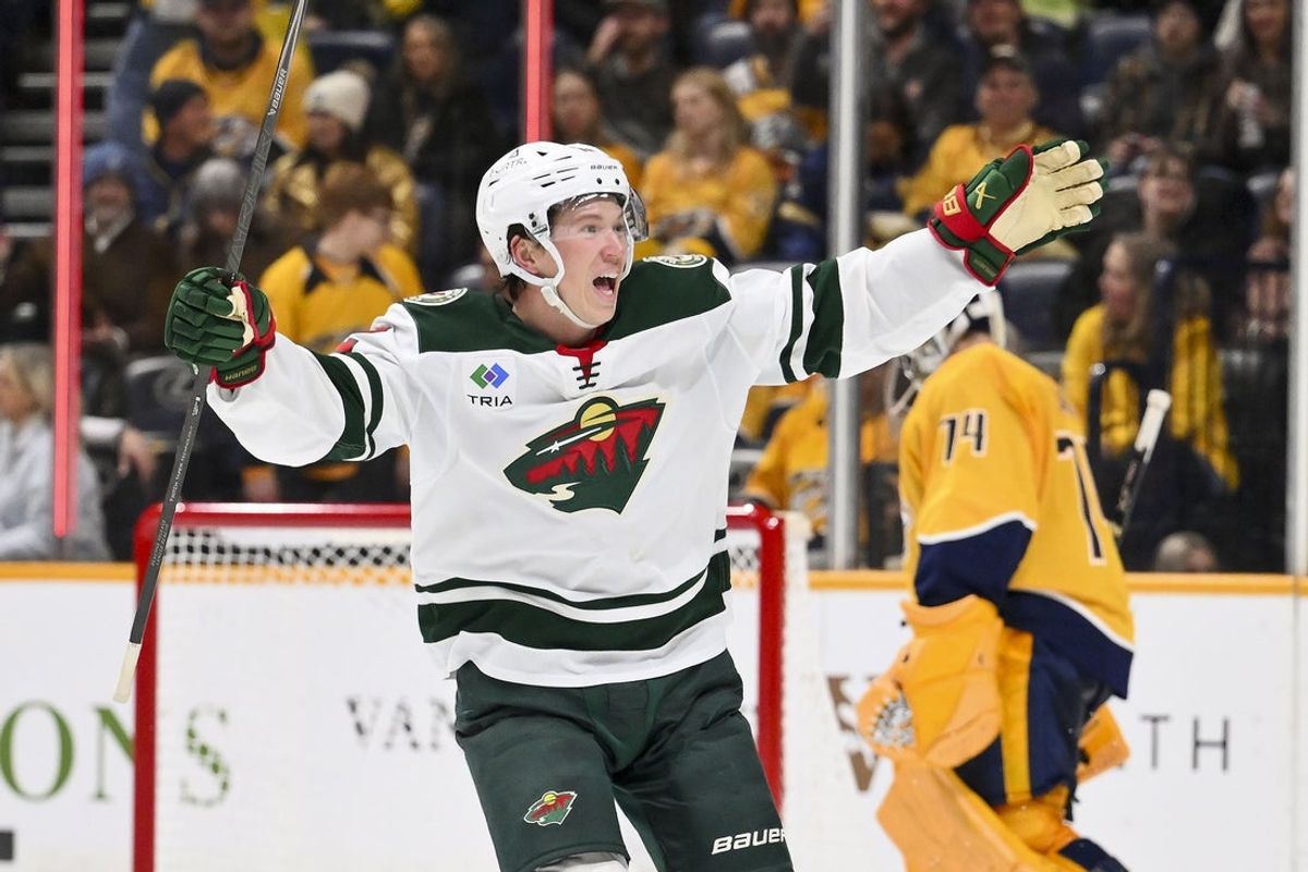 Feb 4, 2026; Nashville, Tennessee, USA;  Minnesota Wild left wing Matt Boldy (12) celebrates defenseman Jared Spurgeon (46) winning goal against the Nashville Predators during the overtime period at Bridgestone Arena. Mandatory Credit: Steve Roberts-Imagn Images