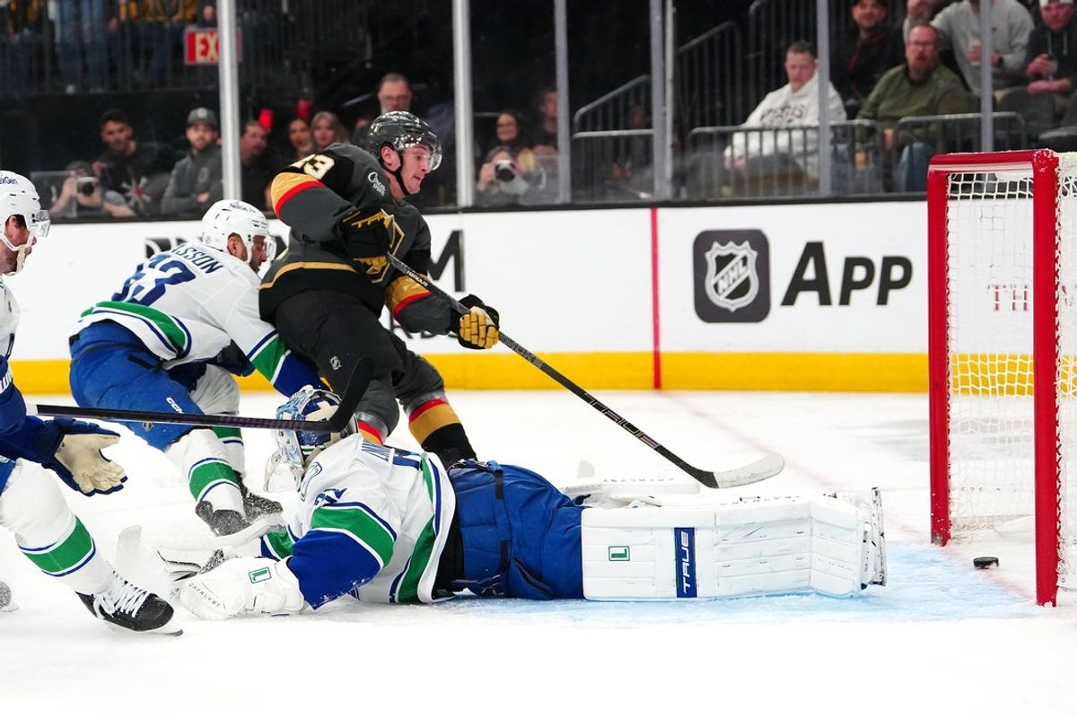 Feb 4, 2026; Las Vegas, Nevada, USA; Vegas Golden Knights left wing Cole Reinhardt (23) scores a goal against Vancouver Canucks goaltender Kevin Lankinen (32) during the second period at T-Mobile Arena. Mandatory Credit: Stephen R. Sylvanie-Imagn Images