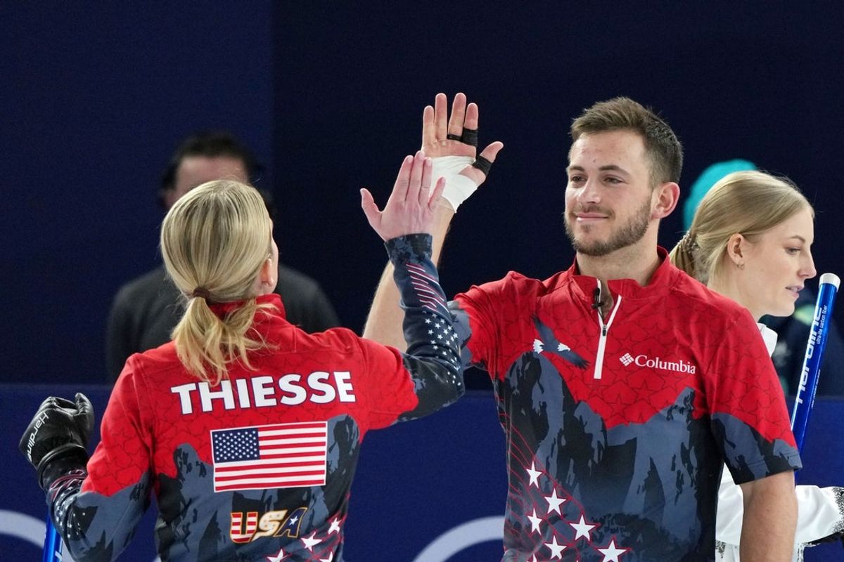 Feb 5, 2026; Cortina d'Ampezzo, Italy; Cory Thiesse and Korey Dropkin of Team United States high five during curling mixed doubles round robin competition during the Milano Cortina 2026 Olympic Winter Games at Cortina Curling Olympic Stadium. Mandatory Credit: Eric Bolte-Imagn Images